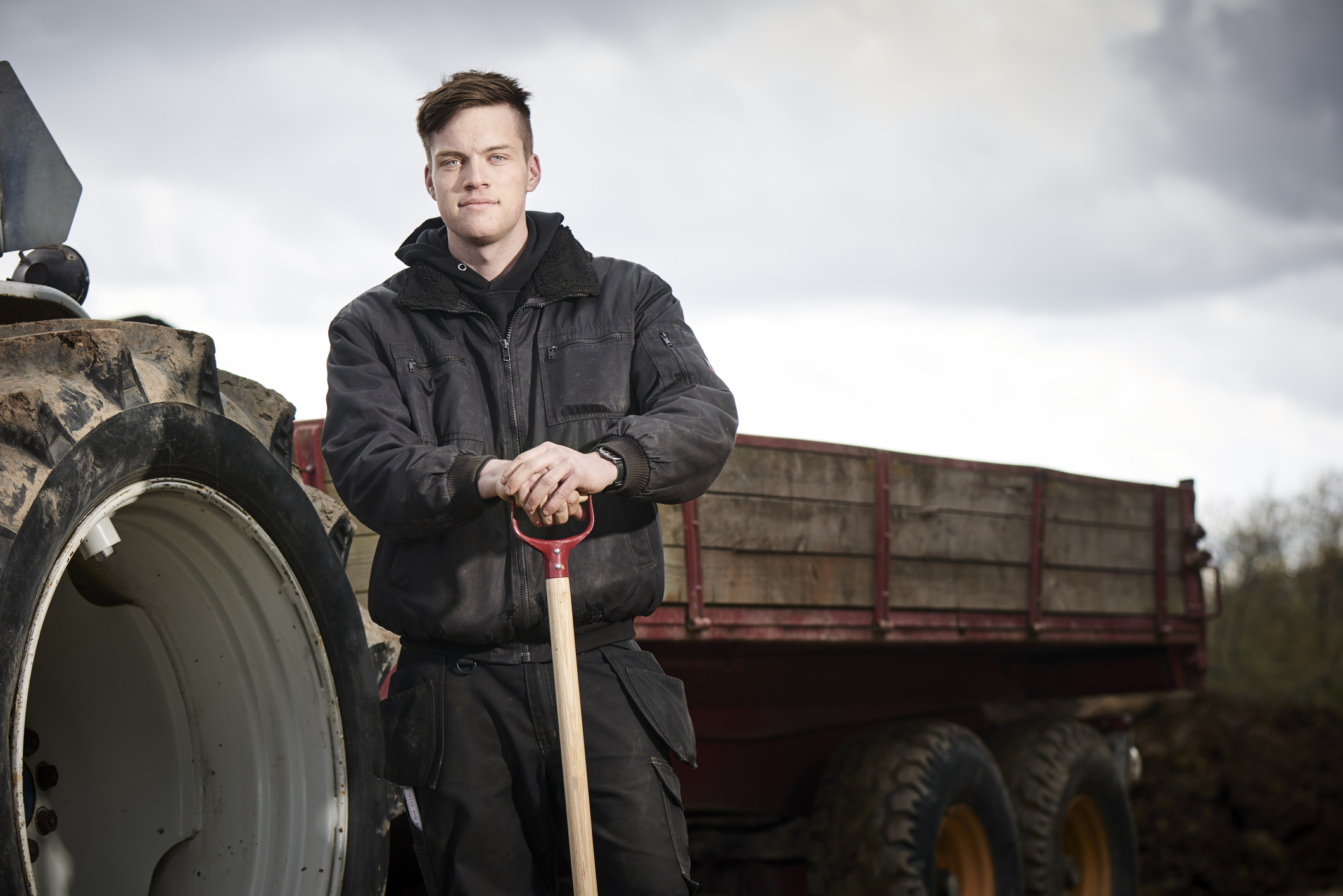 Young Farmer standing by tractor