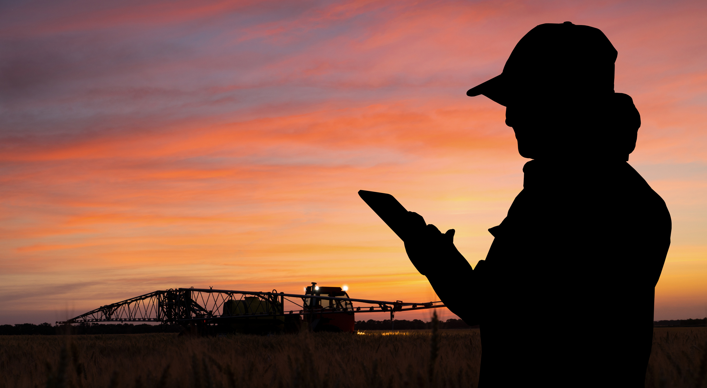 Agricultural Engineer controls sprayer with a tablet at night. 