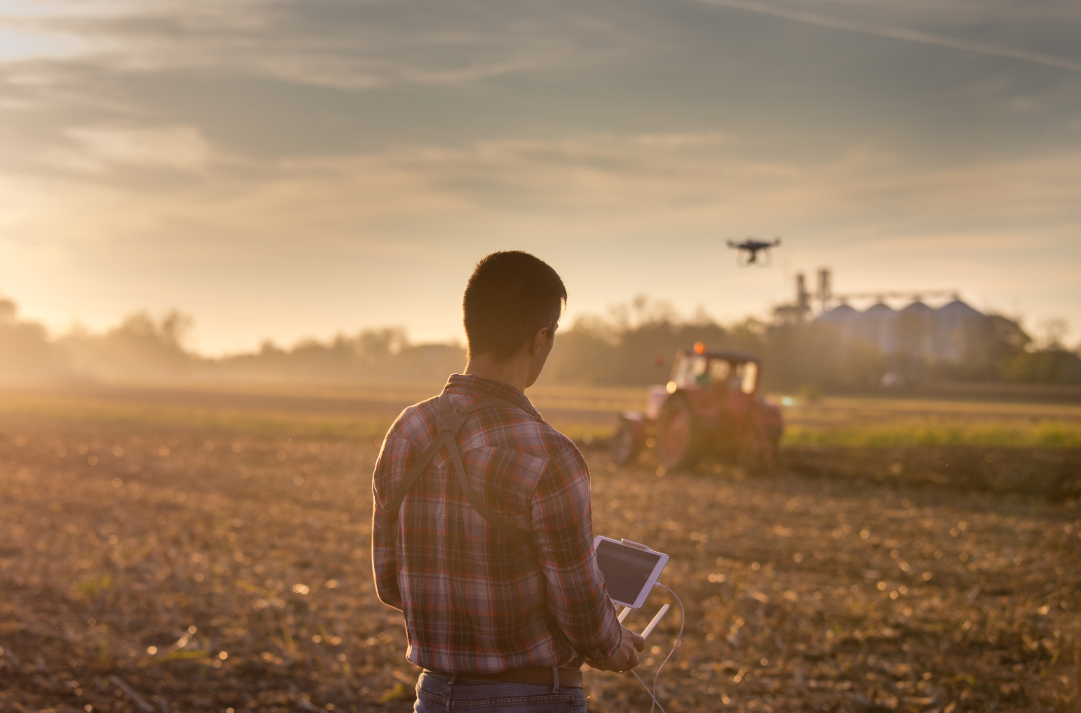 Farmer in a field navigating drone farm technology